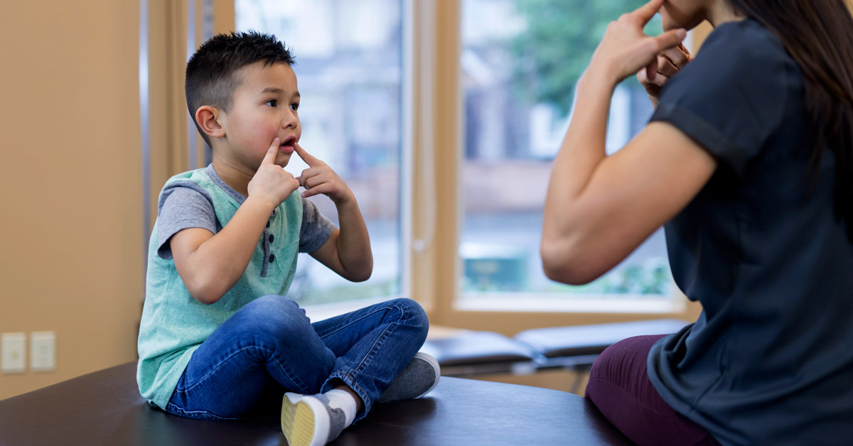 Speech therapist works with a young ethnic boy